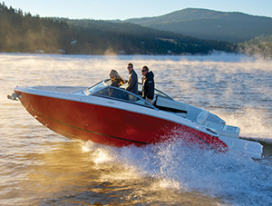 Red and white sports boat planing across the water.