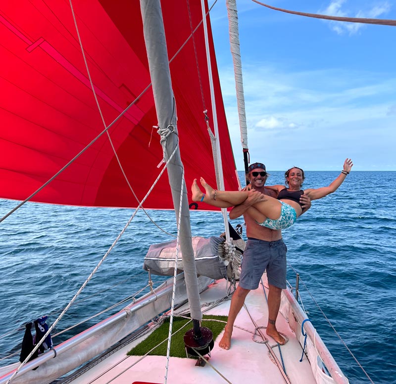 Sailing NV on the bow of their ex-Vendee Globe Open 66 sailing yacht