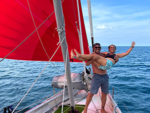 Jo and Timo of Sailing NV on the bow of their ex-Vendee Globe Open 66 sailing yacht
